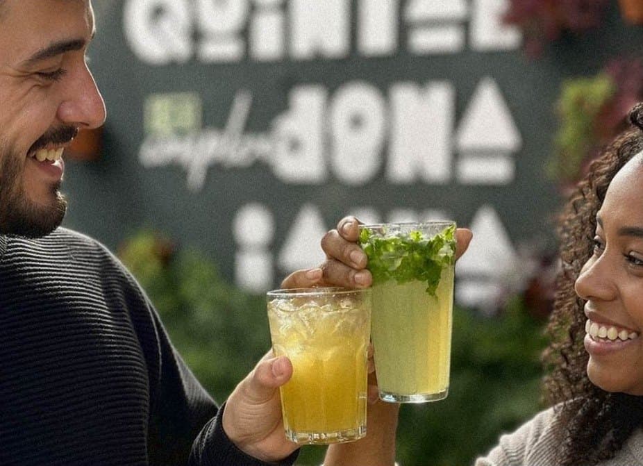 Brinde com drinks em frente ao letreiro